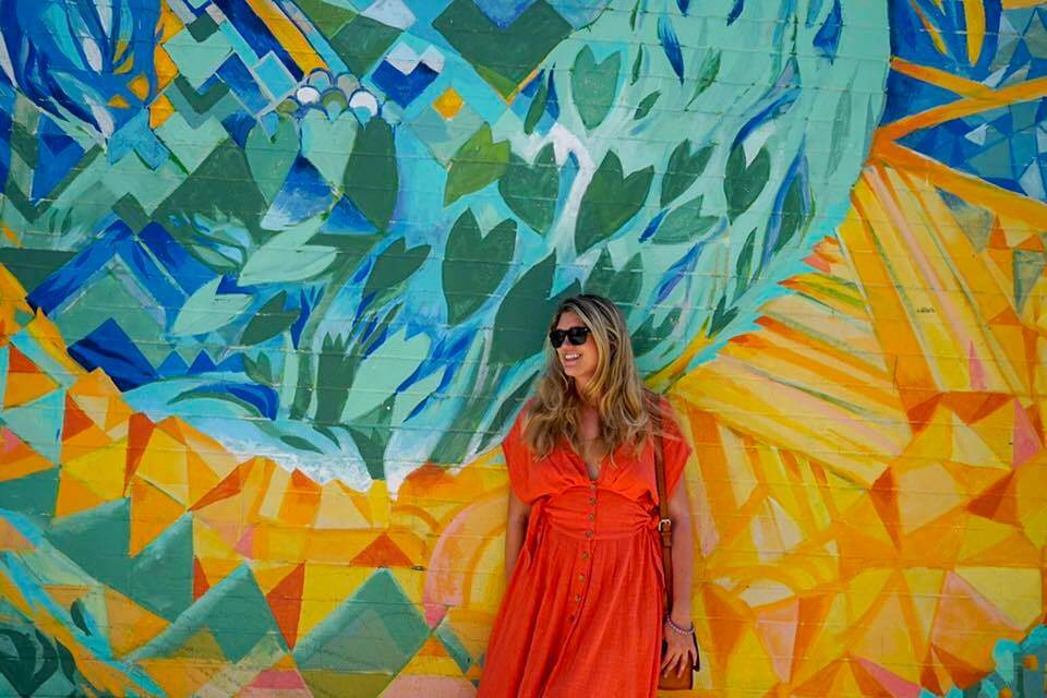 a women standing in front of a mural