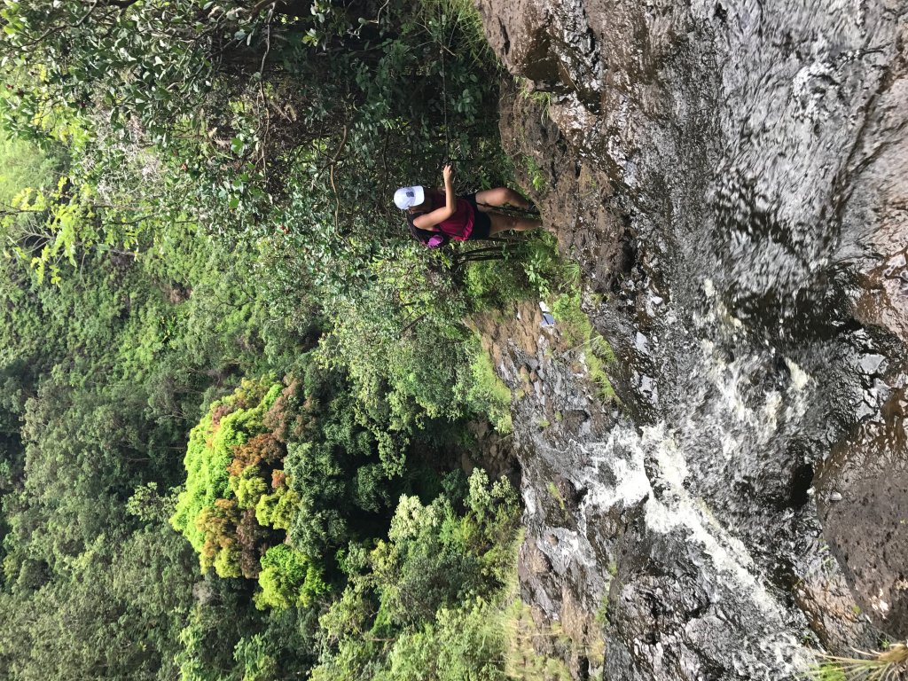 a women climbing up a waterfall 