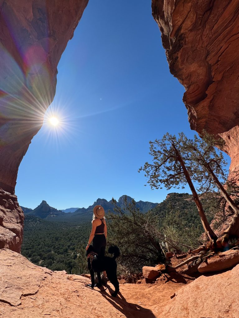 a women and a dog standing in Birthing Cave in Sedona, AZ