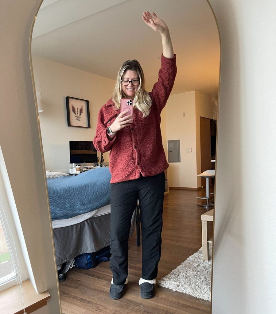 a women holding her arm in the air taking a selfie in the mirror