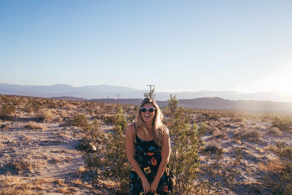 a woman smiling in the middle of the desert