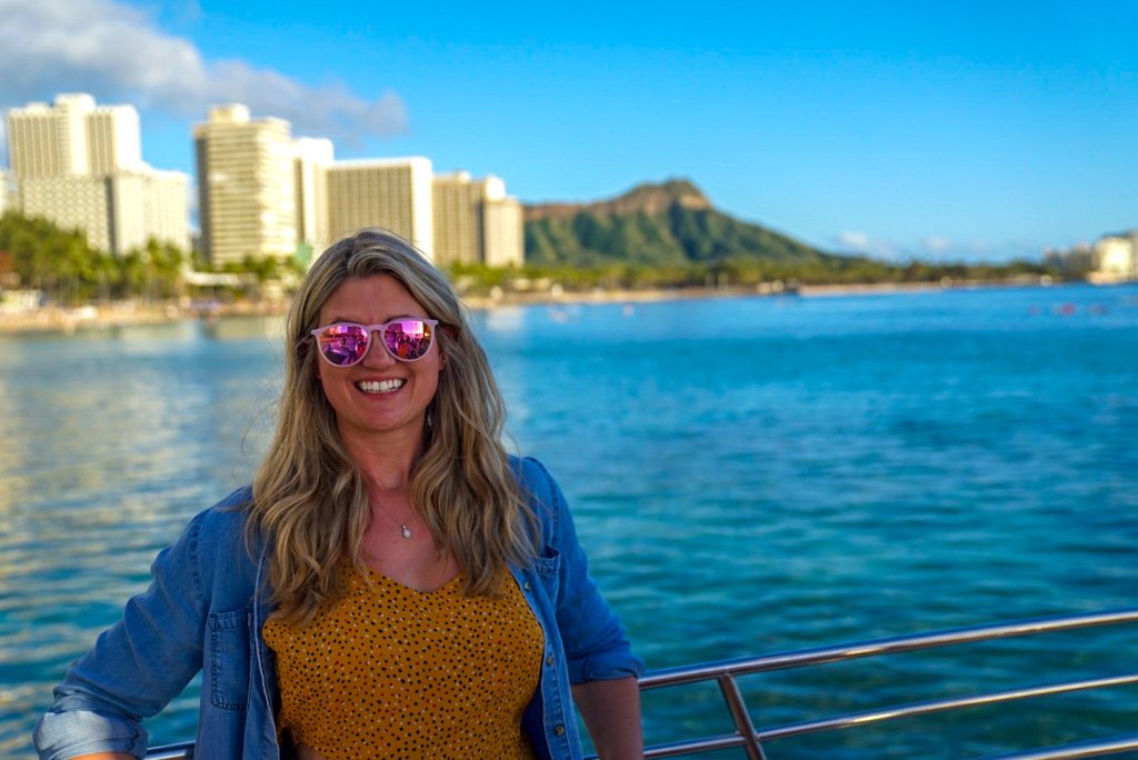 a woman on a boat with diamond head in the background