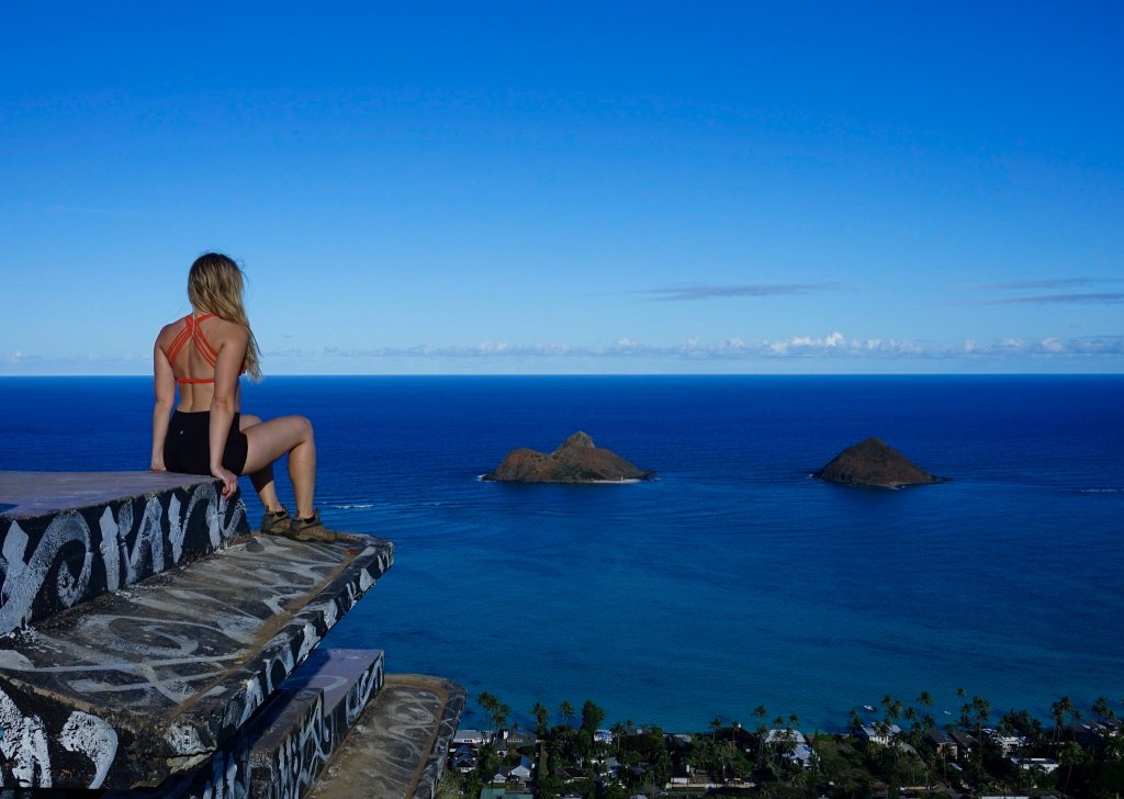 a women sitting on a pillbox looking at the lanikai mokes