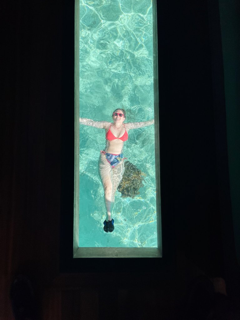 a women floating in the water under a window