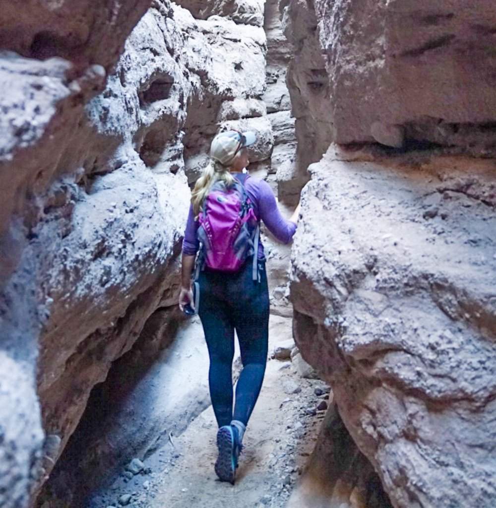 a woman standing in a slot canyon