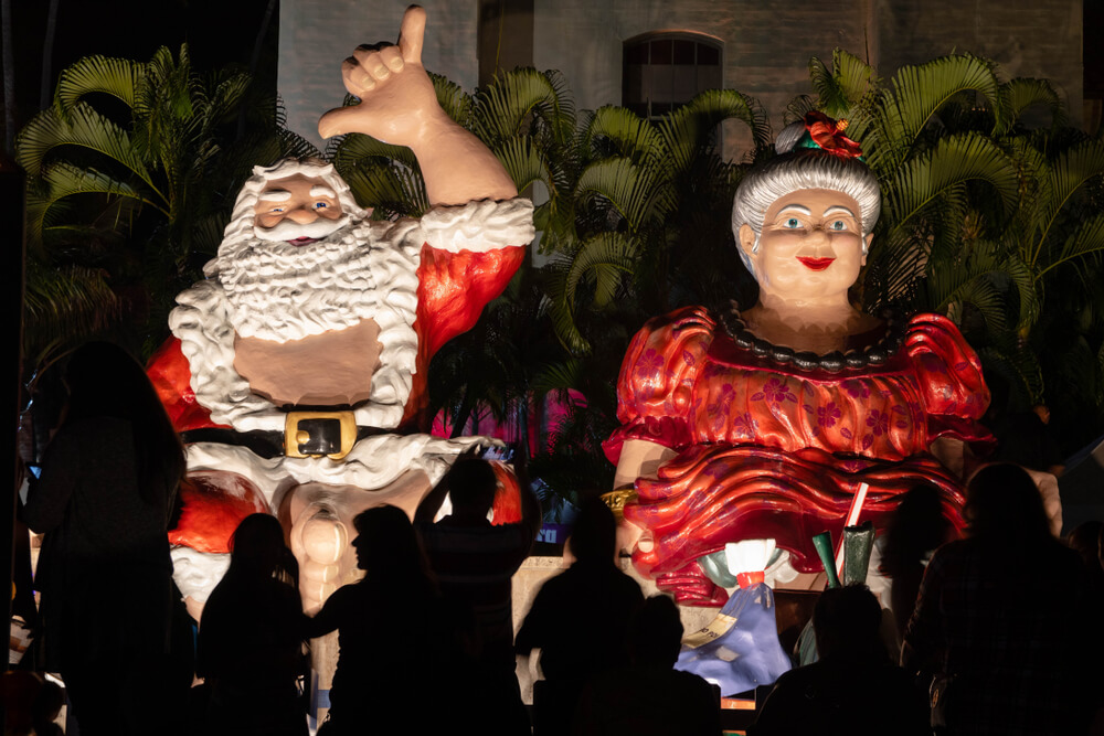 a santa throwing a shaka sign and mrs klaus
