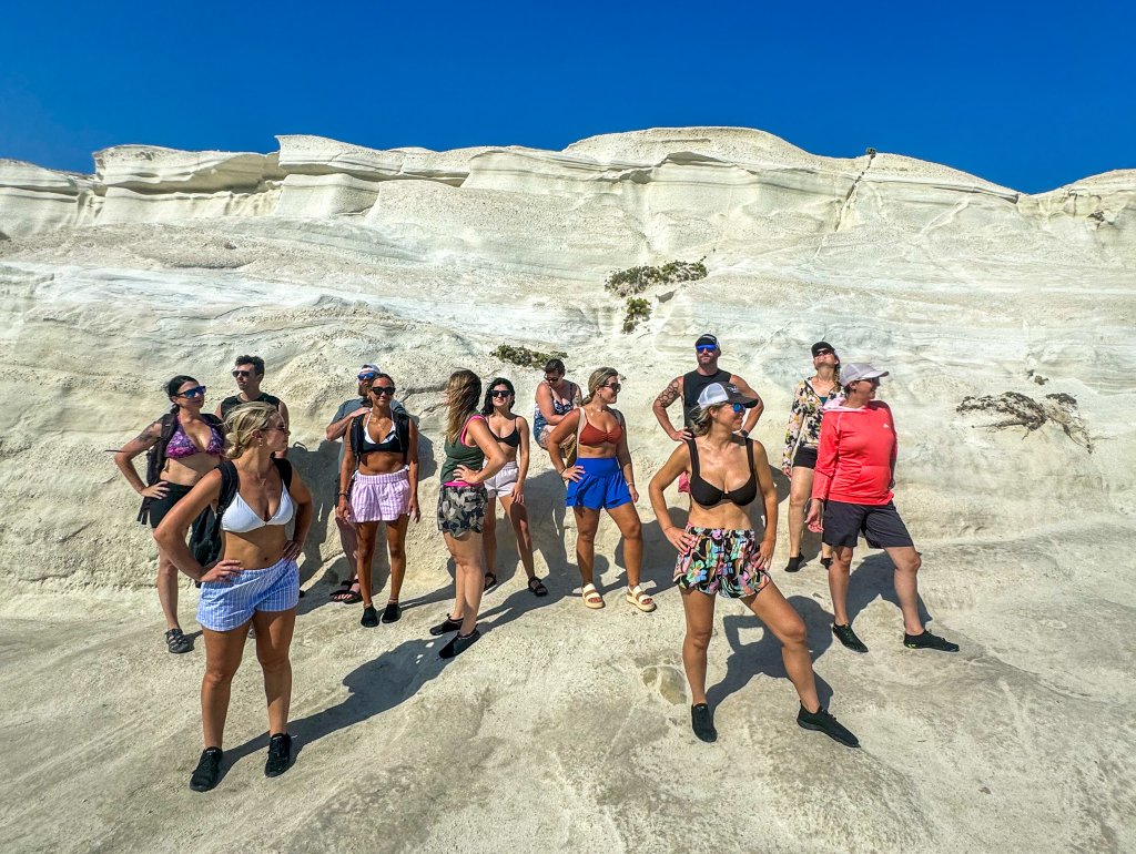 a group standing on a beach in Milos