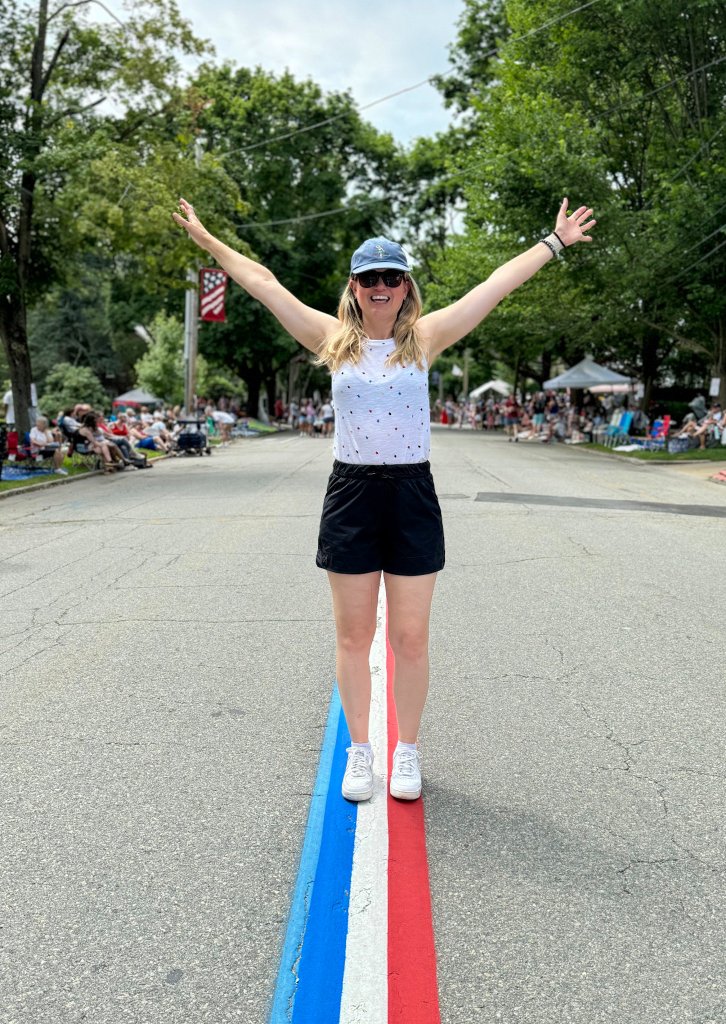 a woman standing on red white and blue street lines in Bristol Rhode Island